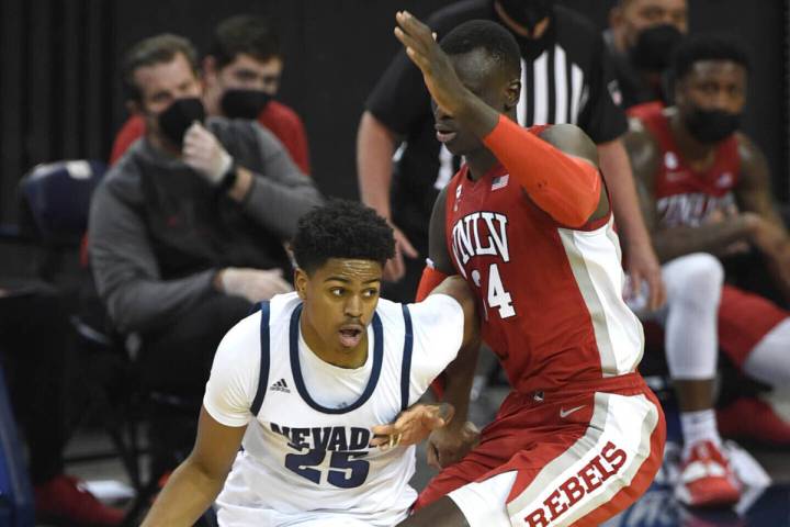 UNR's Grant Sherfield drives against UNLV's Cheikh Mbacke Diong in the first half of an NCAA co ...