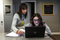 Kim Millard, left, helps daughter Molly with homework while dinner cooks in their home in Layto ...