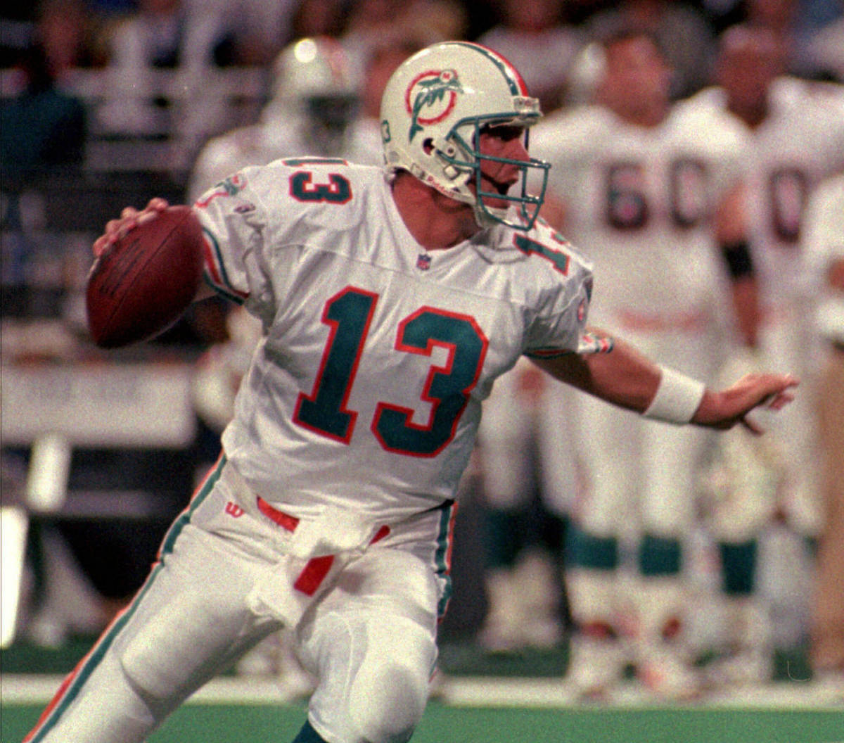 File-This Dec. 24, 1995, file photo shows Miami Dolphins quarterback Dan Marino looking for the ...