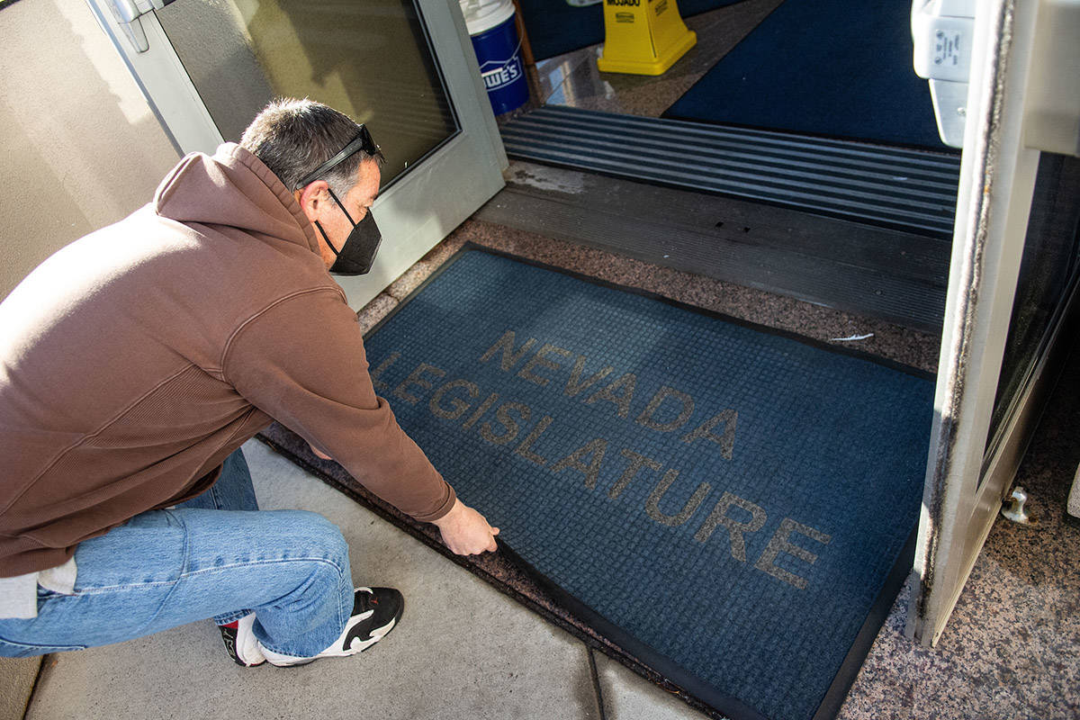 A legislative employee places a mat outside the building on the first day of the 81st session o ...