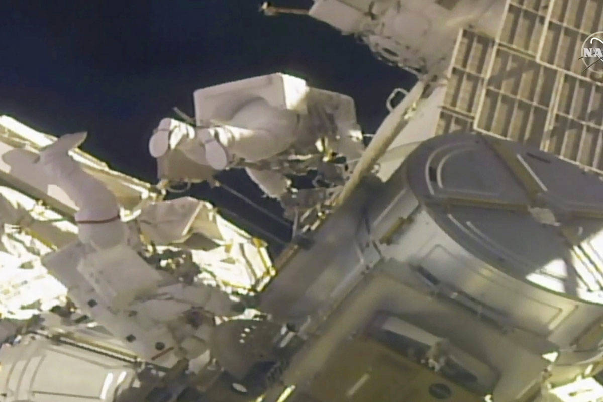 In this image taken from NASA video, NASA astronauts Mike Hopkins, left, and Victor Glover work ...