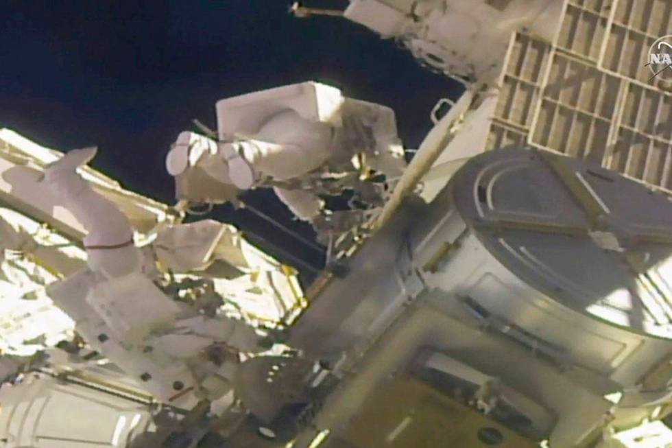 In this image taken from NASA video, NASA astronauts Mike Hopkins, left, and Victor Glover work ...