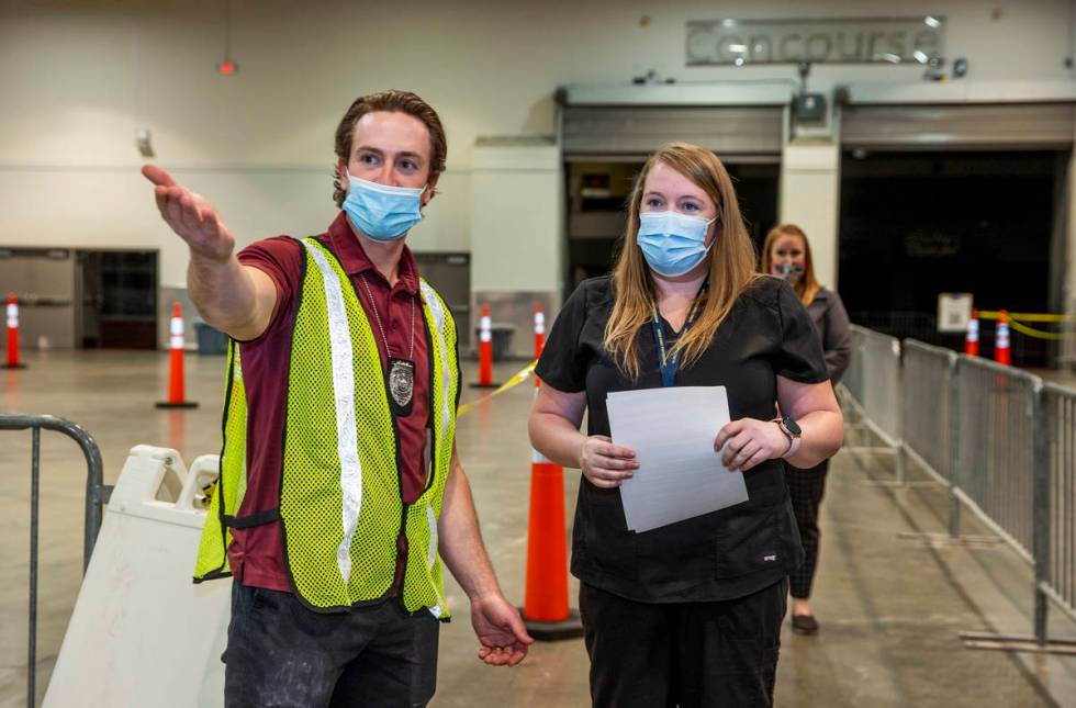 Chris Adams, left, directs Jessica Johnson as she checks in at the Southern Nevada Health Distr ...