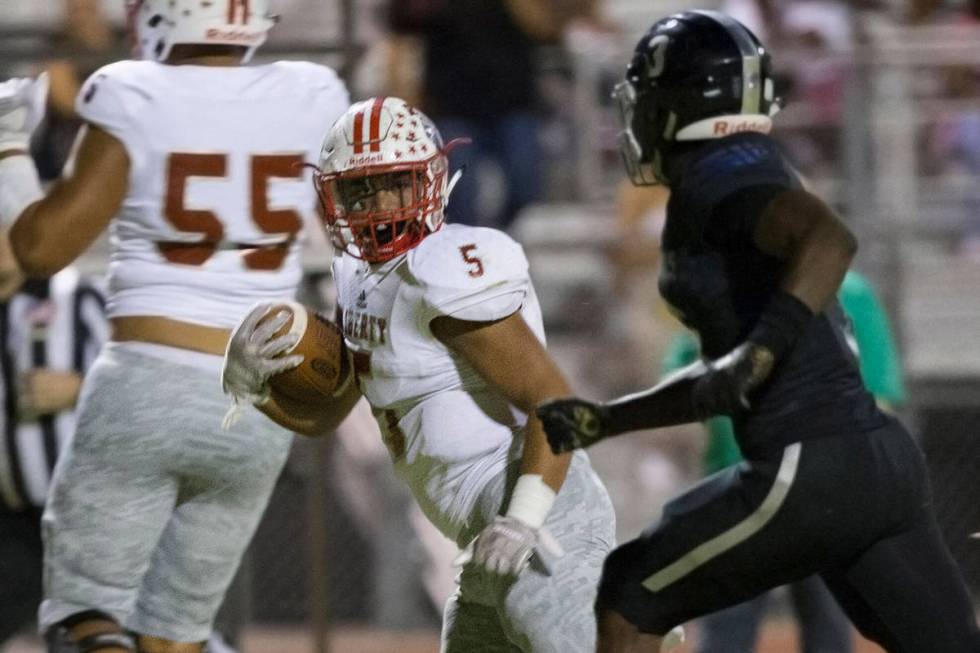 Liberty sophomore running back Ezra Tomhoon (5) breaks into the open field for a first quarter ...