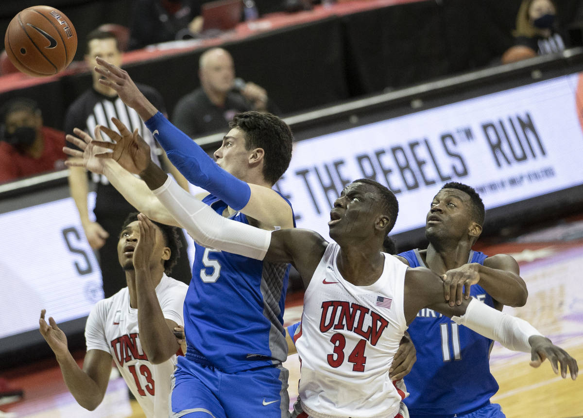 UNLV Rebels forward Cheikh Mbacke Diong (34) fights for a rebound with Air Force Falcons guard ...