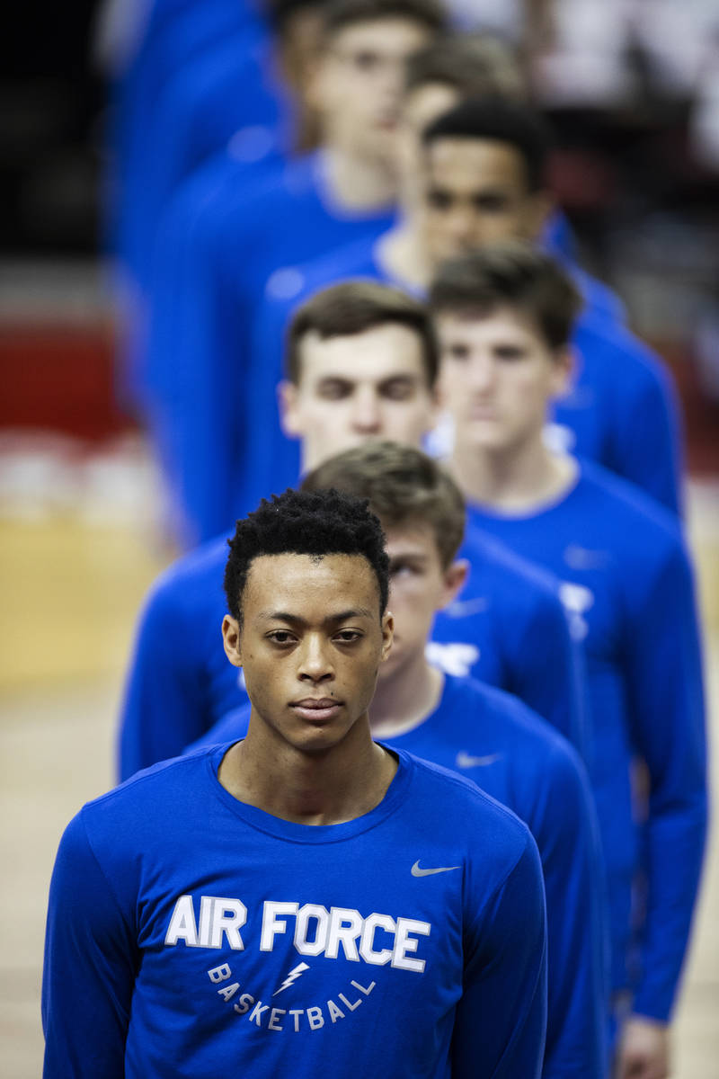 Air Force players listen to the national anthem before the start of an NCAA mens basketball gam ...