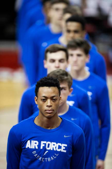 Air Force players listen to the national anthem before the start of an NCAA mens basketball gam ...