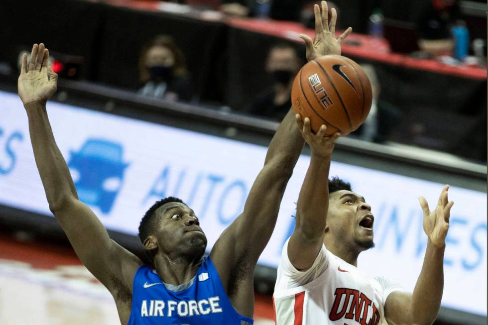 UNLV Rebels guard Bryce Hamilton (13) drives past Air Force Falcons guard Ameka Akaya (11) in t ...