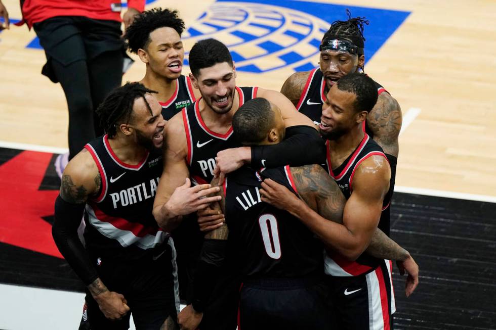 Portland Trail Blazers guard Damian Lillard (0) celebrates with teammates after making the winn ...