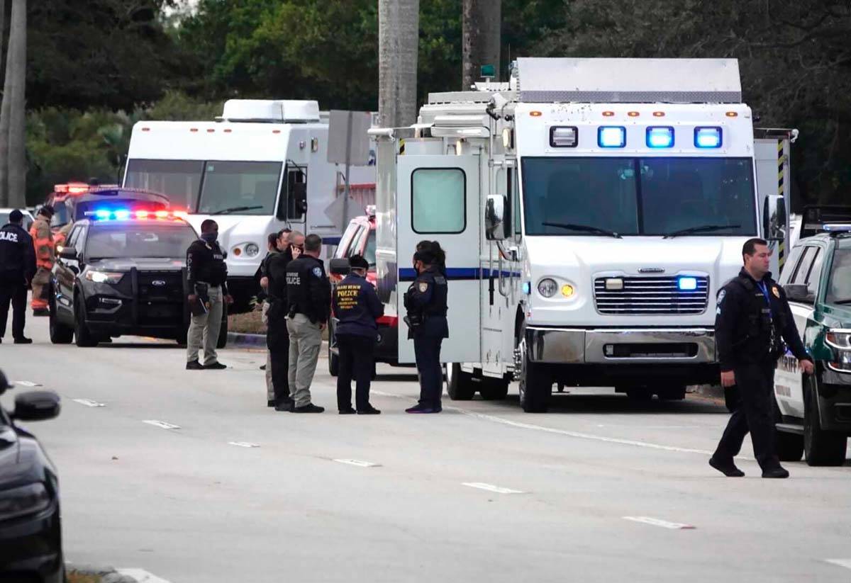 Law enforcement gather near the scene of a shooting that wounded several FBI agents in Sunrise, ...