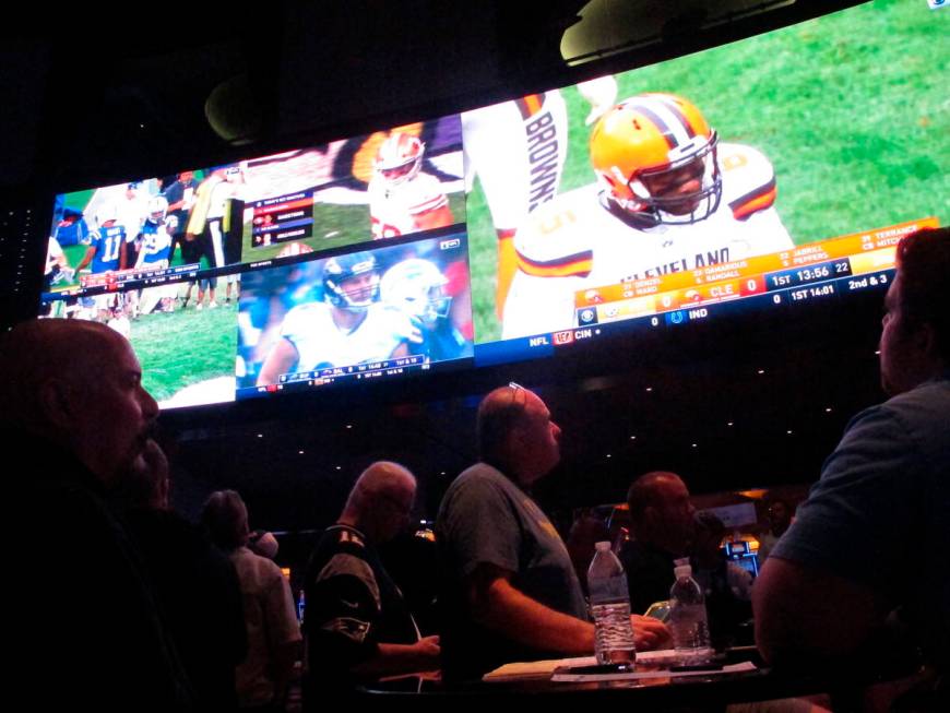 This Sept. 9, 2018 photo shows football fans watching the action on wall-mounted video screens ...