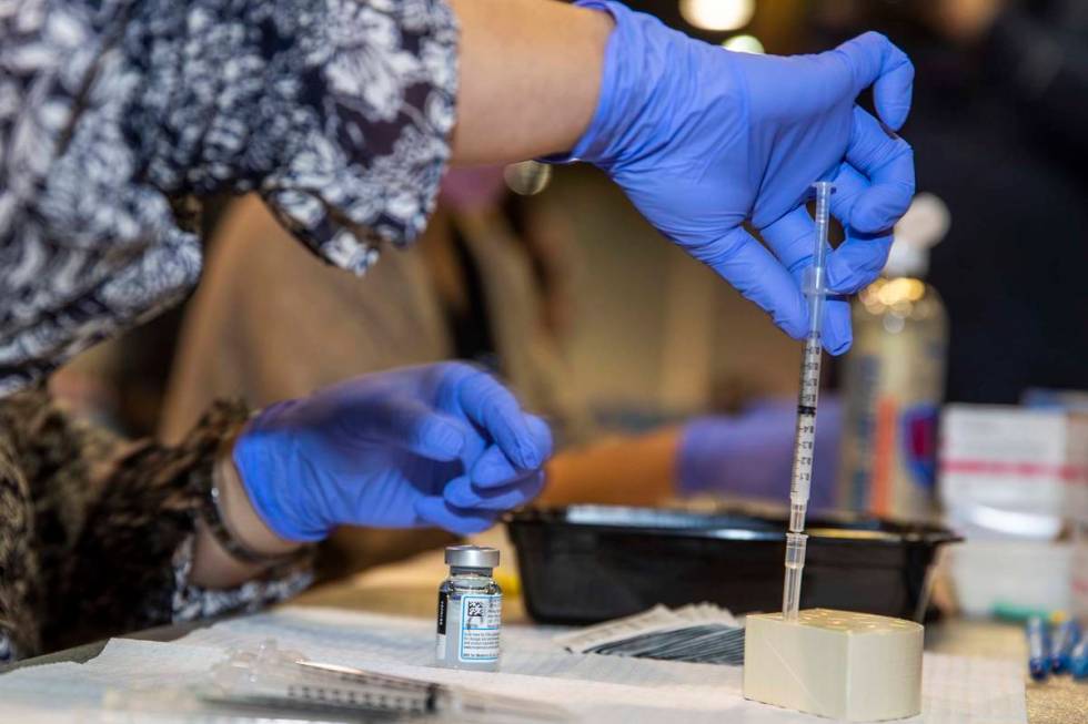 RN Dawn Schuder prepares another dose of the Moderna vaccine at the Southern Nevada Health Dist ...