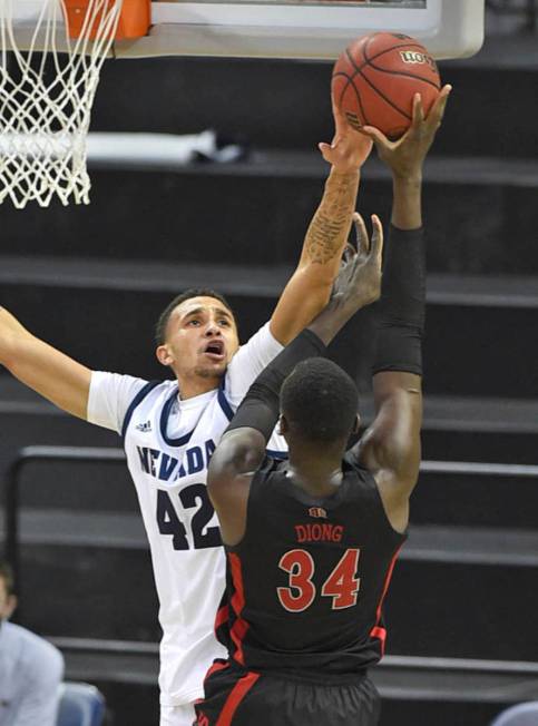 Nevada's Kwamé "K.J." Hymes, Jr. blocks a shot attempt by UNLV 's Cheikh Mbacke ...