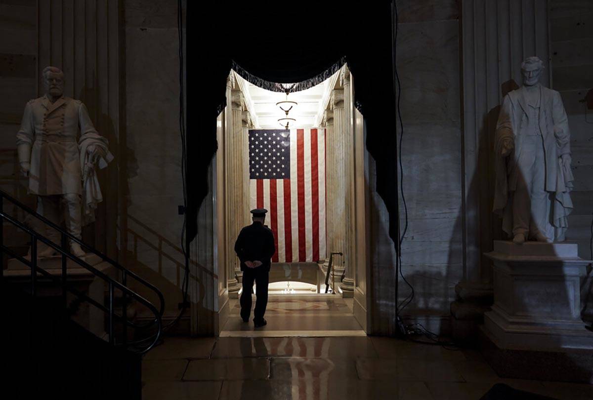 A U.S. Capitol Police officer stands at the door of the Capitol Rotunda near where the late U.S ...