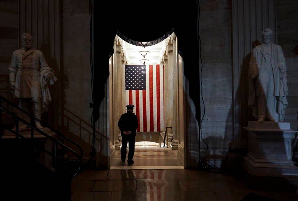 A U.S. Capitol Police officer stands at the door of the Capitol Rotunda near where the late U.S ...