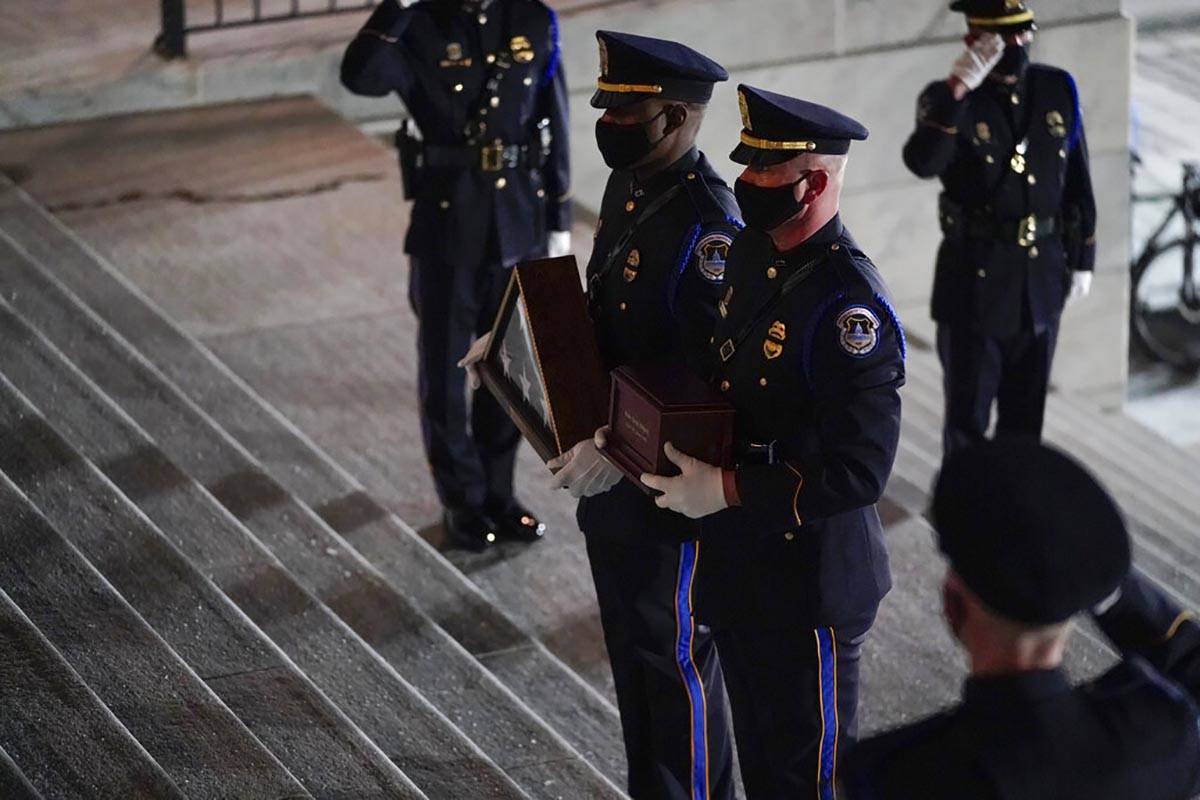 An honor guard carries an urn with the cremated remains of U.S. Capitol Police officer Brian Si ...