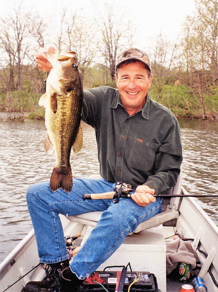 Bass Pro Shops founder Johnny Morris holds up a large bass, showing he is just as capable at ca ...