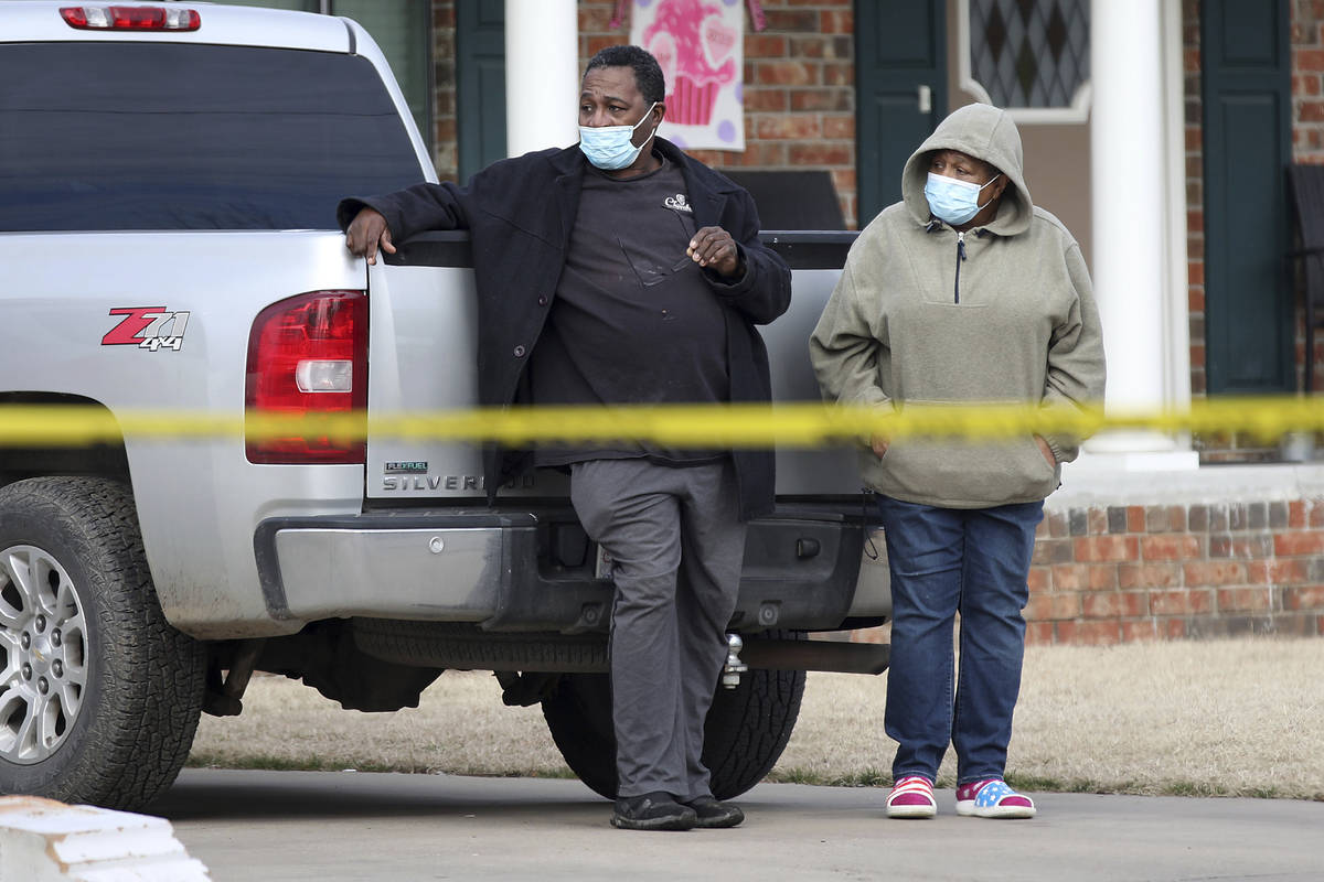 A man and woman watch the scene of a shooting on Tuesday, Feb. 2, 2021 in Muskogee, Okla. Poli ...