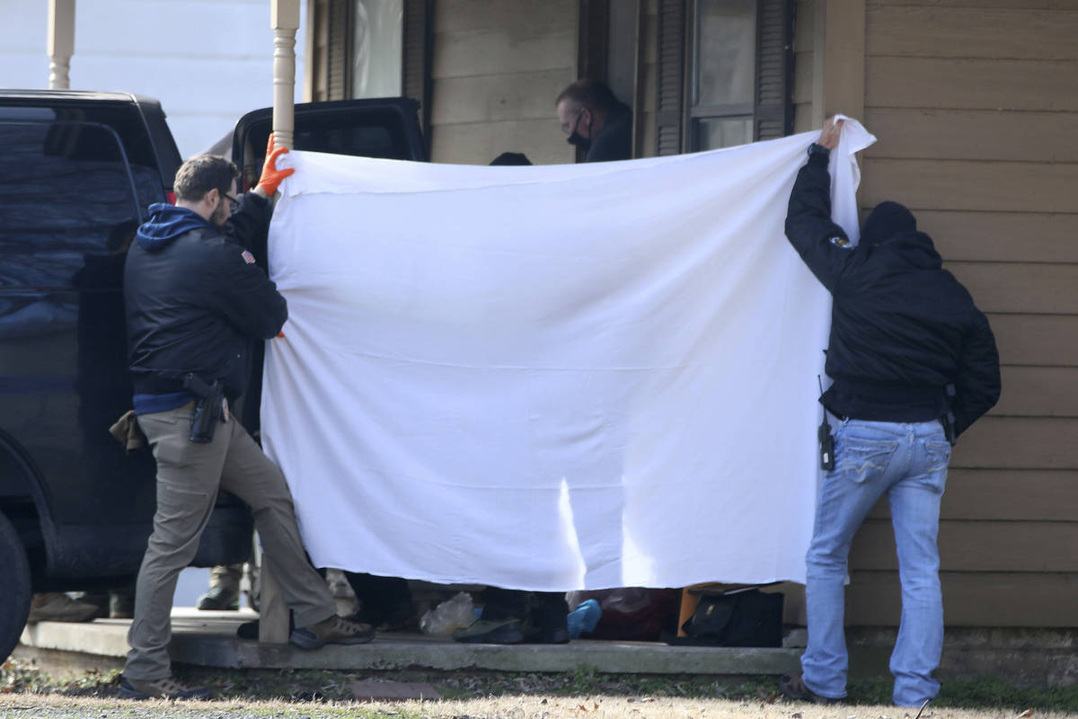 Investigators block the public's view as bodies are removed from the scene of a shooting on Tue ...