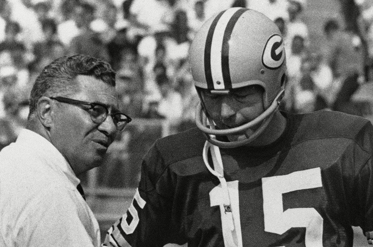 Green Bay Packer coach Vince Lombardi speaks with quarterback Bart Starr (15) and as the Packer ...