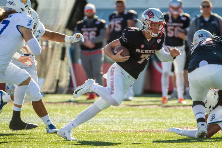 UNLV Rebels quarterback Kenyon Oblad (7) cuts up field through the San Jose State Spartans defe ...