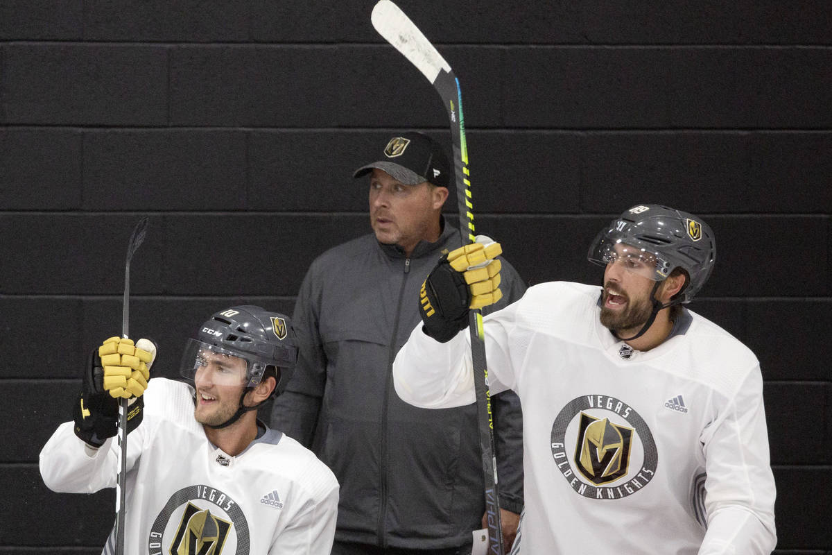 In this July 20, 2020, file photo, Golden Knights' assistant coach Steve Spott, center, is seen ...
