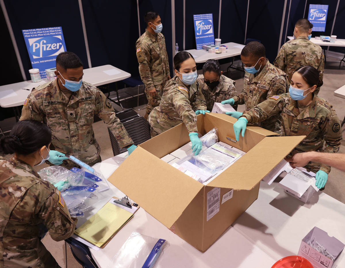 Nevada National Guard members unload the ancillary kit that was delivered with the Pfizer vacci ...