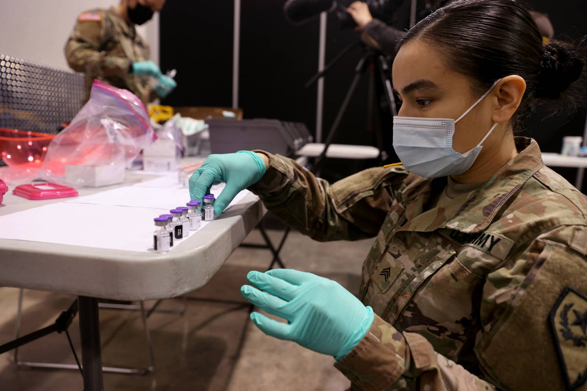 Nevada National Guard Sgt. Candy "D.T." Delatorre prepares Pfizer vaccine at the Cashman Center ...