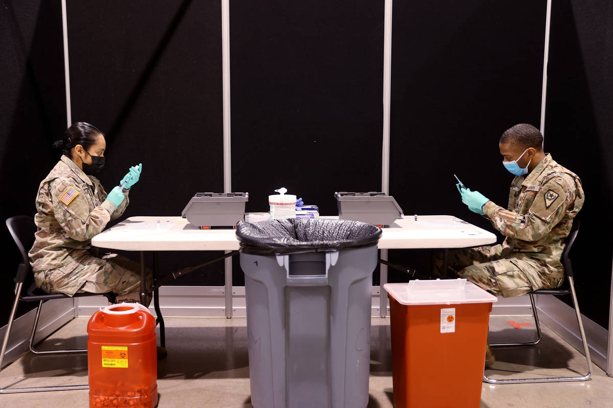 Nevada National Guard members, Pfc. Kimberly Hernandez and Spc. Keith Davis, prepare Pfizer vac ...