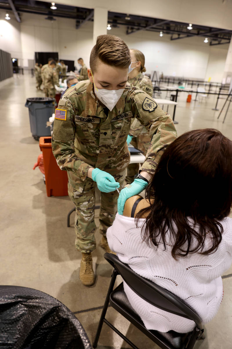 Nevada National Guard Spc. Katherine Deskins administers the Pfizer vaccine shot to Barbara Moo ...