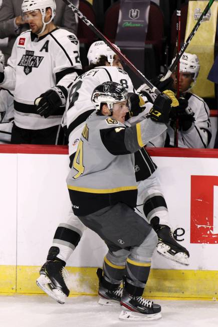 Henderson Silver Knights defenseman Jimmy Schuldt (4) slams Ontario Reign Daniel Brickley (8) a ...