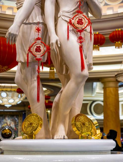 Gold coins and good luck symbols are hung on the statues within the main lobby as part of the d ...