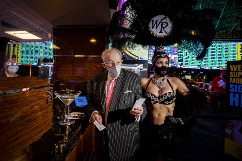 Former Las Vegas Mayor Oscar Goodman, left, is escorted by a showgirl after placing his Super B ...