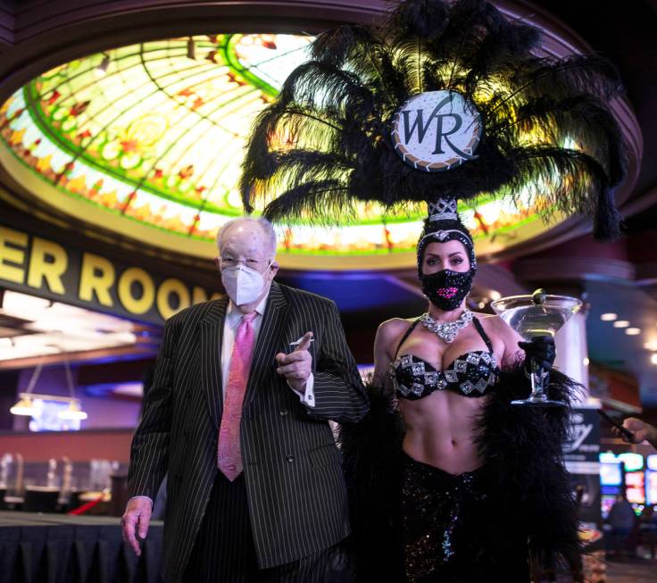 Former Las Vegas Mayor Oscar Goodman, left, is escorted by a showgirl to place his Super Bowl b ...