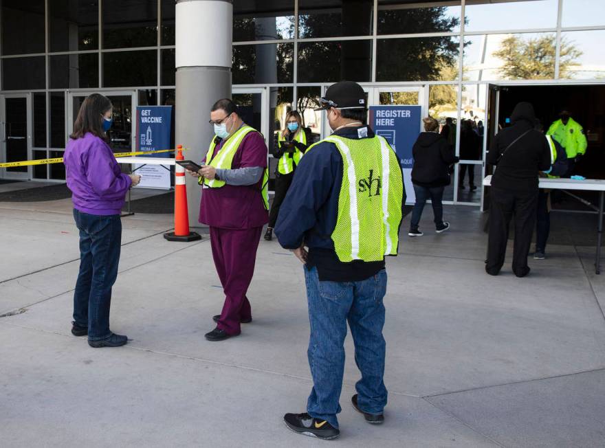 Sym Ciccone, center, a contact tracer from the Southern Nevada Health District, checks in peopl ...