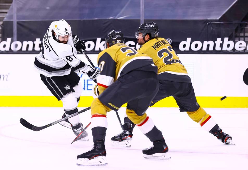 Los Angeles Kings defenseman Drew Doughty (8) shoots between Golden Knights defensemen Shea The ...