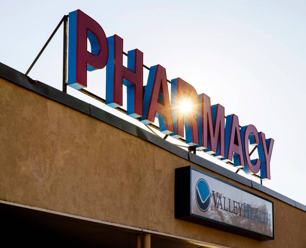 The sun rises behind a Fruth pharmacy sign on Wednesday, Feb. 3, 2021, in Charleston, W.Va. (L. ...