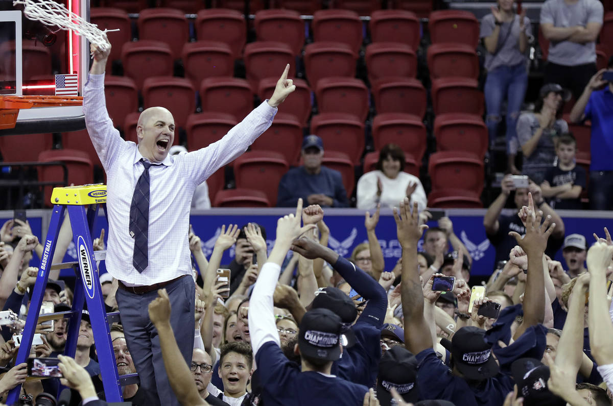 Utah State's head coach Craig Smith cuts off the net following an NCAA college basketball game ...