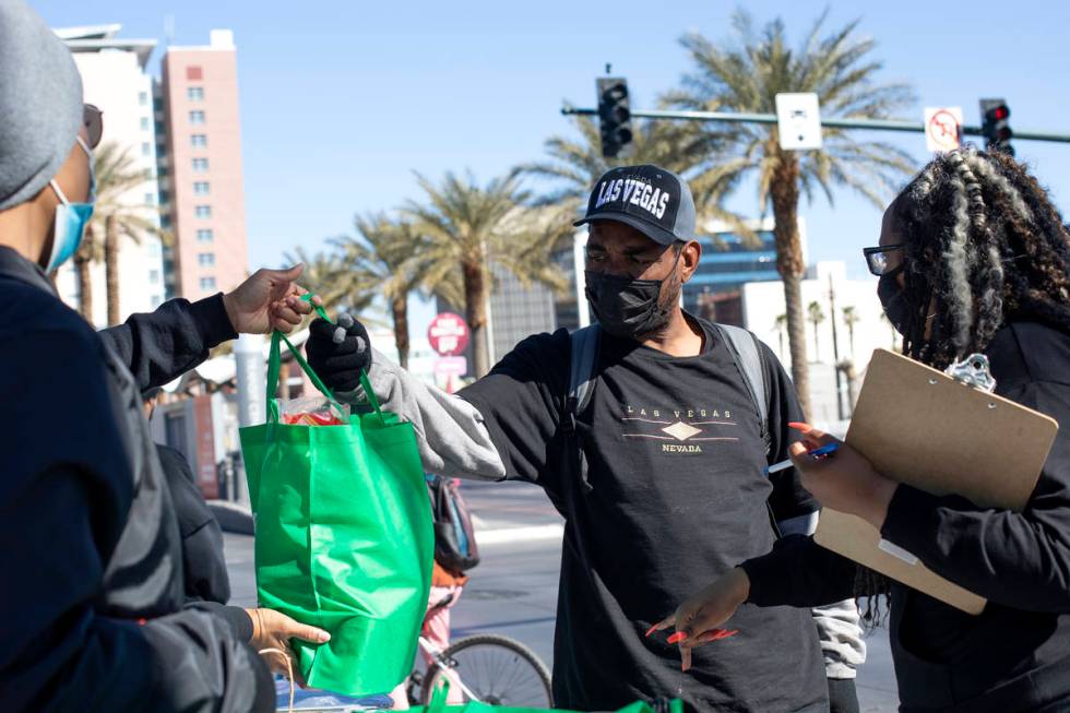 Lawrence Gene accepts a bag of groceries from New Era Las Vegas members during their Mary Wesle ...