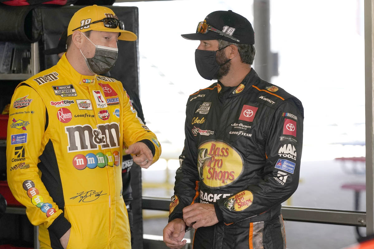 Kyle Busch, left, and Martin Truex Jr. talk in the garage before a NASCAR Daytona 500 auto race ...