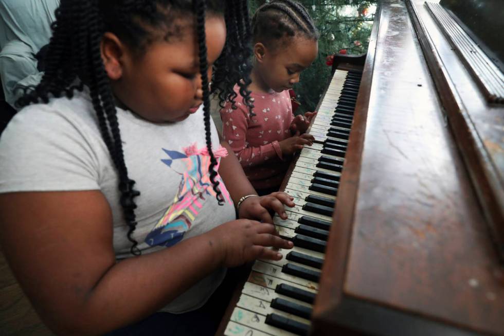 Brittani, left, and Lear Preston play the piano in their living room after their virtual school ...