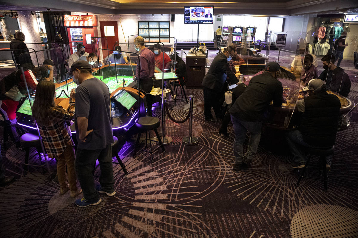 People play craps on two tables at the Harrahs's Las Vegas hotel-casino, including the new digi ...