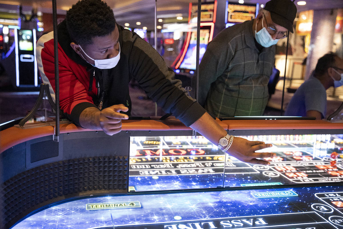 Fredrick Nolen of Chicago rolls dice on the new digital craps table, Rolls to Win Craps, at the ...