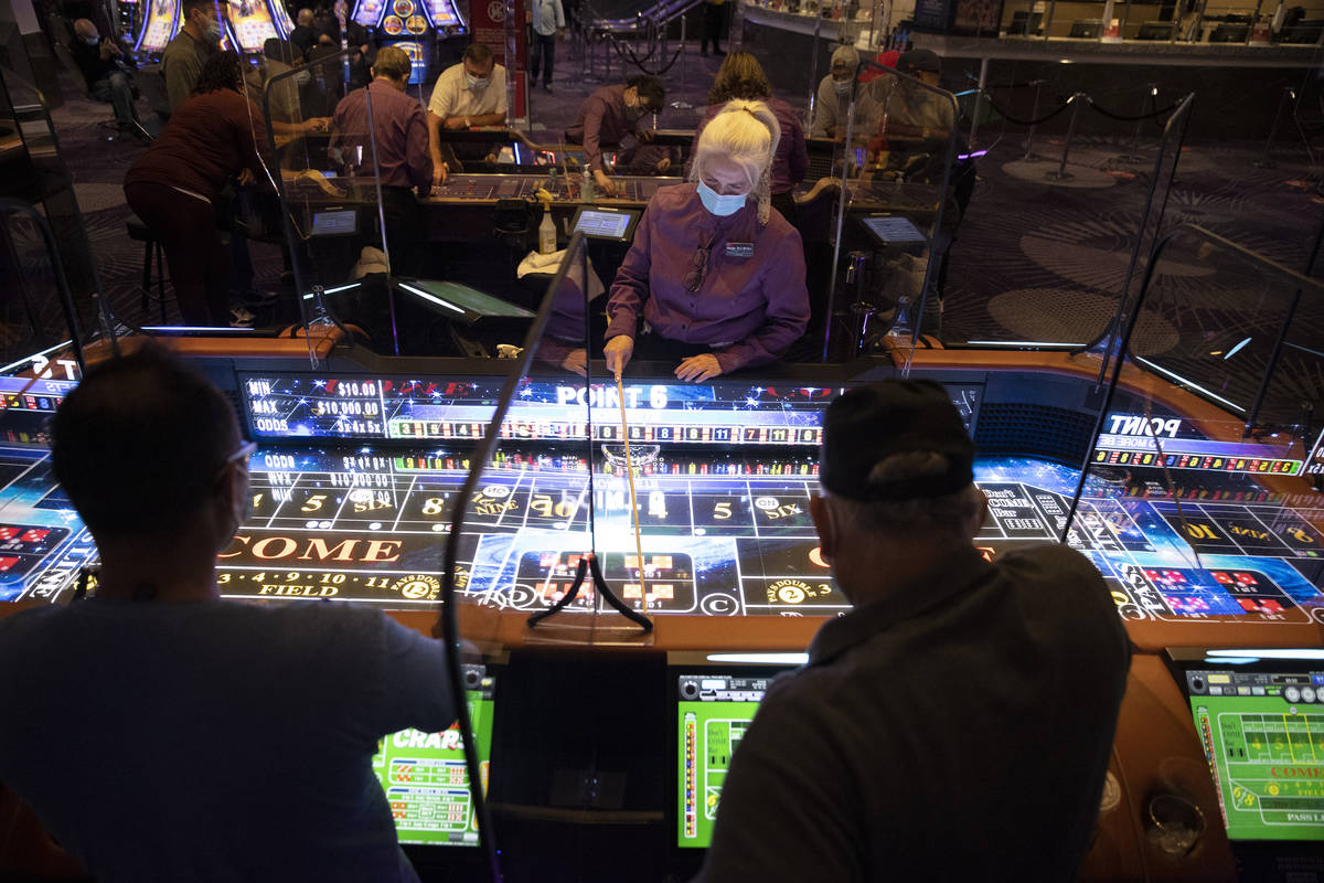 Table game dealer Valentina Chtchevelva handles dice with a stick on the new craps table, Rolls ...