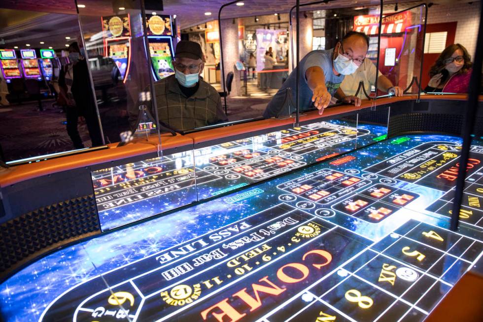 Rio Bencito of Los Angeles rolls dice on the new digital craps table, Rolls to Win Craps, at th ...