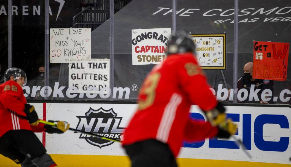 Golden Knights players skate past signs during warm ups before the first period of an NHL game ...