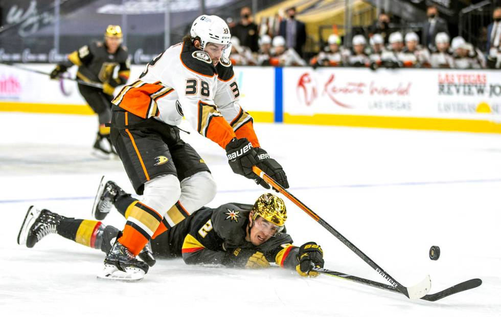 Golden Knights defenseman Zach Whitecloud (2) is taken down to the ice by Anaheim Ducks center ...