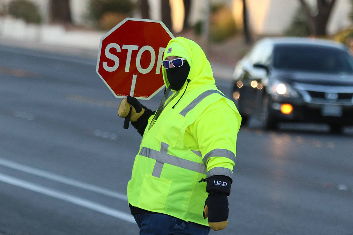 Crossing guard Paul Kotoch bundled up against the cold as he he directs traffic on Wednesday, O ...