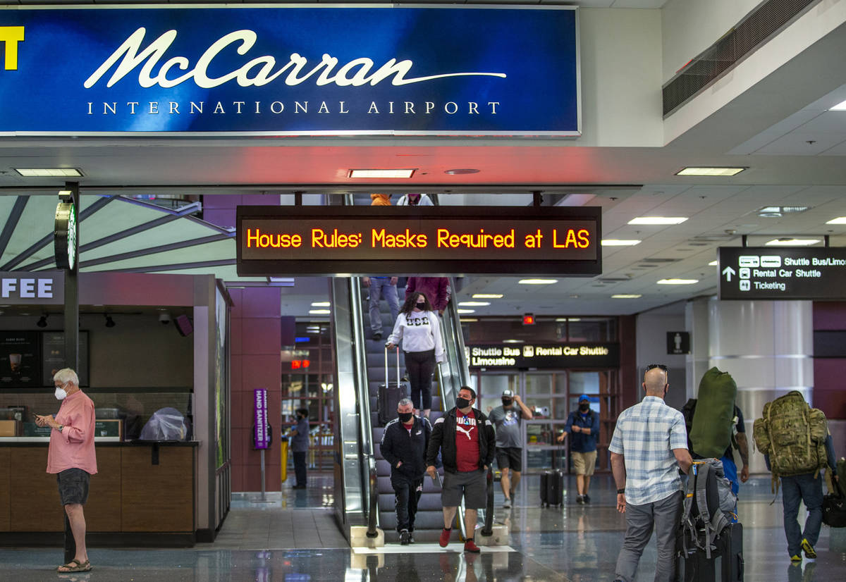 Passengers move about the Terminal 1 baggage claim area at McCarran International Airport on We ...