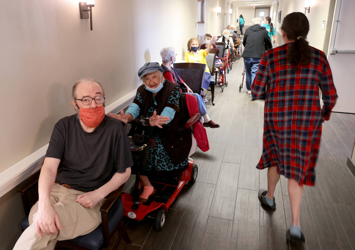 Michael Chernoff, 65, and Valmae Ayres, 98, wait in line for the COVID-19 vaccine during an in- ...